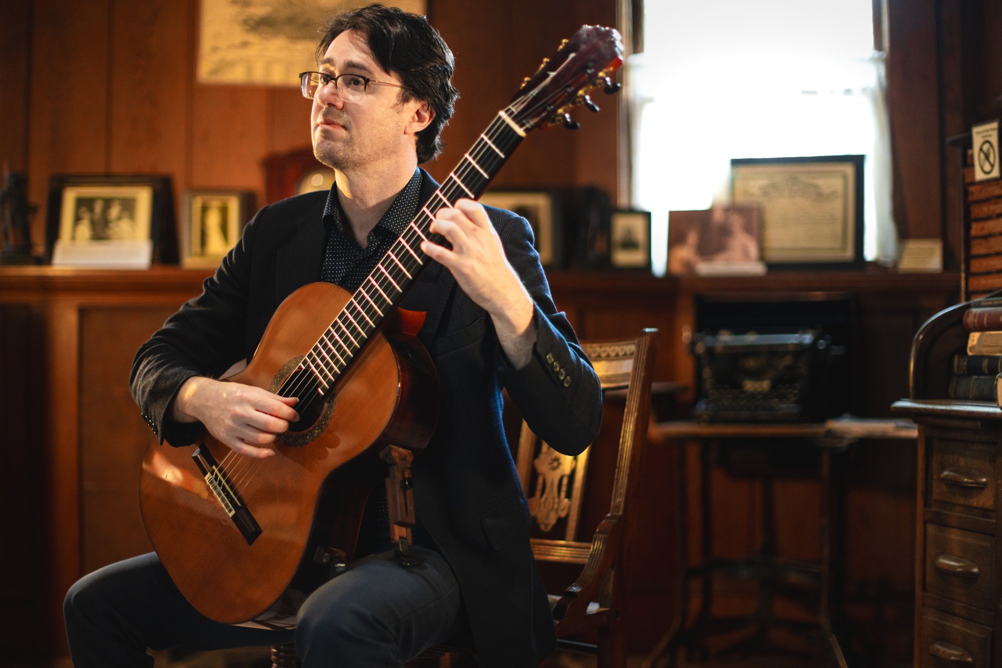 Yuri Liberzon looking up as he plays classical guitar